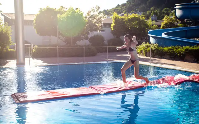 Frau auf Laufmatte in Freibad